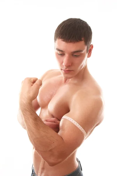 Young bodybuilder measuring his biceps — Stock Photo, Image