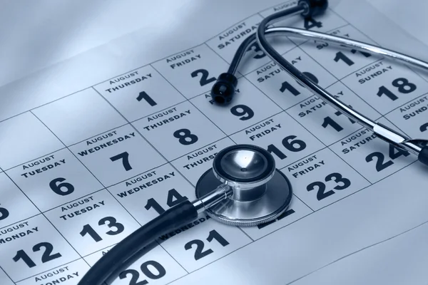 Ein Stethoskop über einem Kalender — Stockfoto