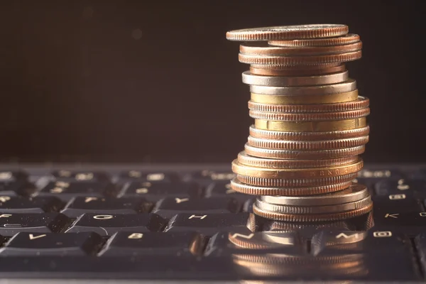 Coin pile over a keyboard — Stock Photo, Image