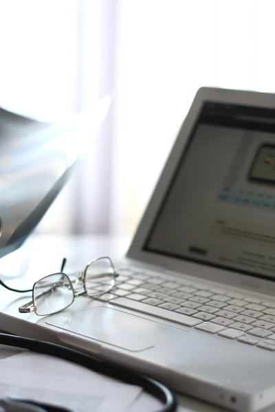 Gafas en un portátil, el lugar de trabajo de un médico — Foto de Stock