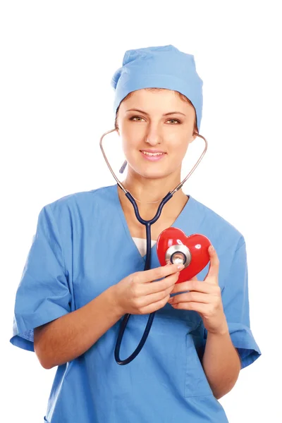 Arzt mit Stethoskop untersucht rotes Herz — Stockfoto