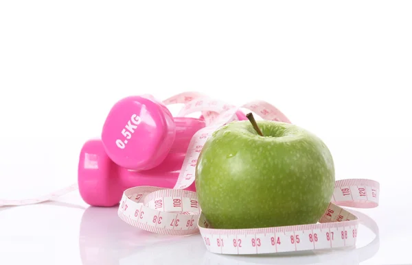 Measure tape, apple and dumbbells — Stock Photo, Image