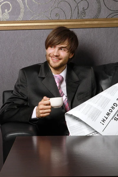 Бизнесмен с чашкой кофе и газетой — стоковое фото