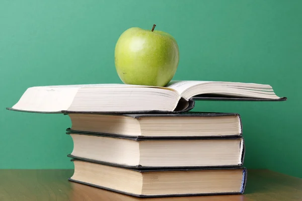 Яблоко над книгами — стоковое фото