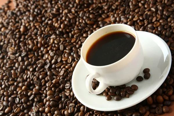 Een kopje koffie en koffiebonen — Stockfoto