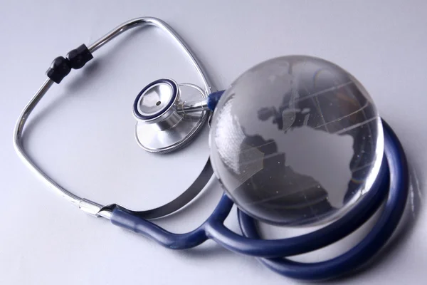 Closeup of a stethoscope and a globe — Stock Photo, Image