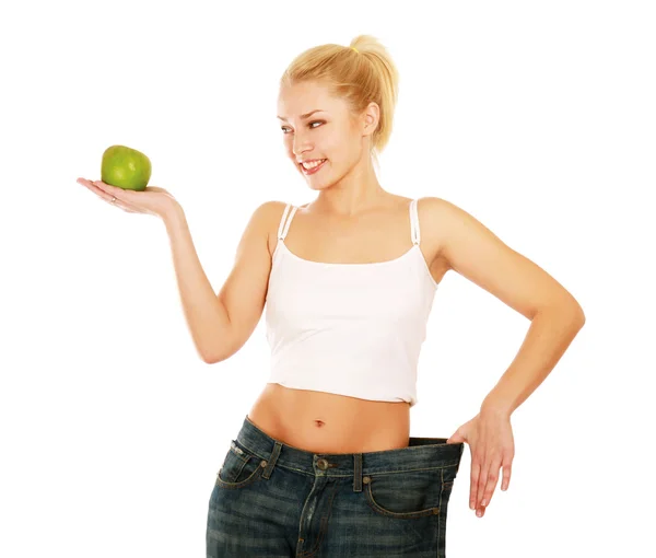 Młoda dziewczyna z dużym dżinsy i apple — Zdjęcie stockowe