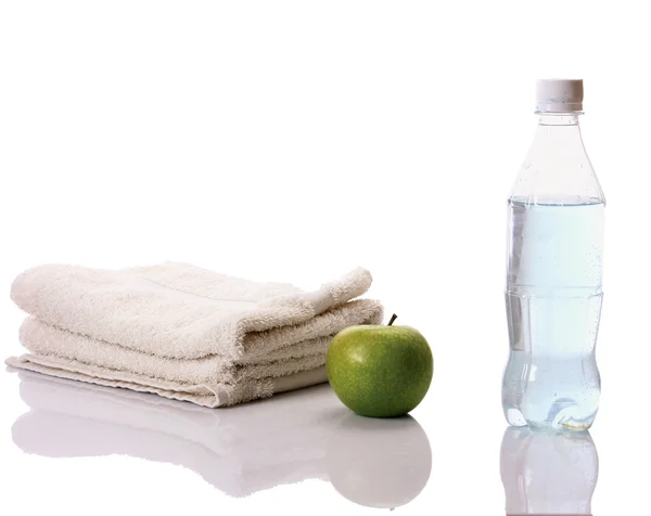 Полотенце, яблоко и бутылка с водой — стоковое фото