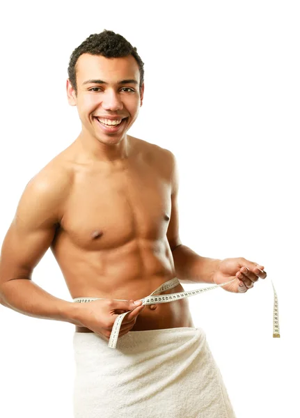 Man covering himself with a towel with tape measuring — Stock Photo, Image