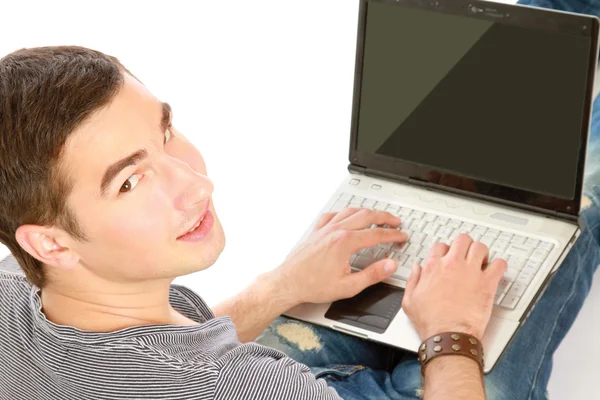 Ragazzo seduto sul pavimento con un computer portatile — Foto Stock