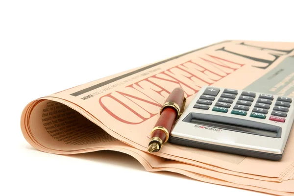 Pen and calculator on newspaper — Stock Photo, Image
