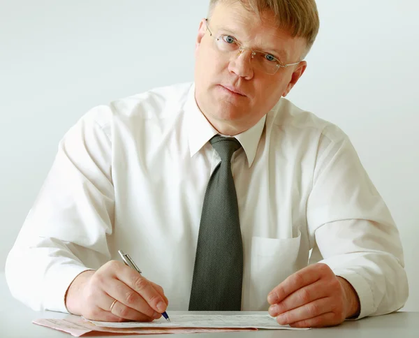 Biznesmen siedzi na biurku i pisania — Zdjęcie stockowe