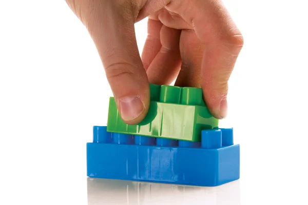 Multi-coloured plastic blocks in hand — Stock Photo, Image