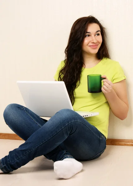 Flicka med laptop och hålla cup — Stockfoto