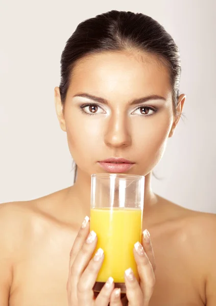 Jovem mulher bebendo suco de laranja — Fotografia de Stock