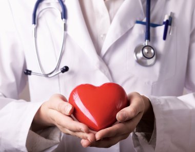 Steteskoplu doktor kalbi tutuyor.