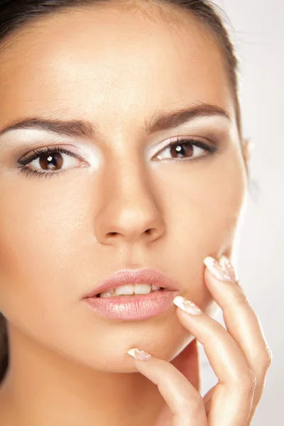 Mujer joven tocando su cara — Foto de Stock