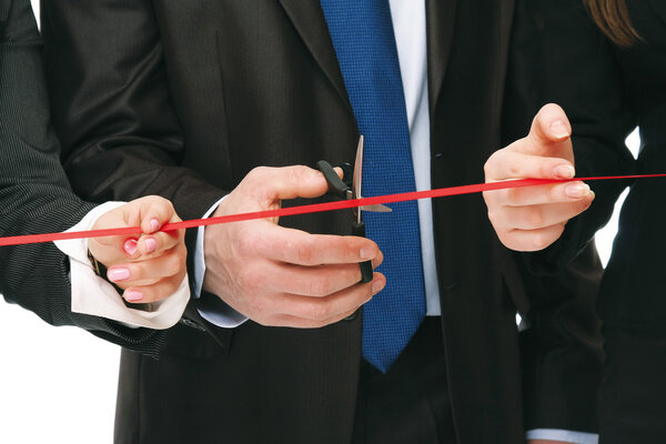 Business people cutting a red ribbon