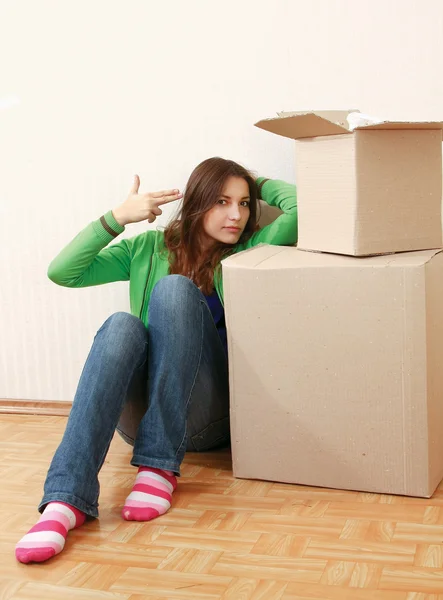 Woman sitting on the floor near boxes — Stock Photo, Image