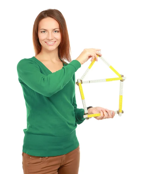 Mujer sosteniendo una regla en la forma de una casa — Foto de Stock