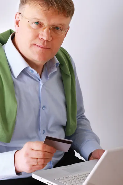 Homme avec un ordinateur portable et carte de crédit — Photo