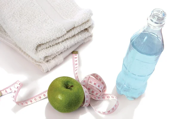 Ręcznik, jabłko, pomiar taśmy i butelki z wodą — Zdjęcie stockowe