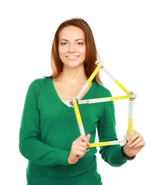 Woman holding a ruler in the form of a house — Stock Photo, Image