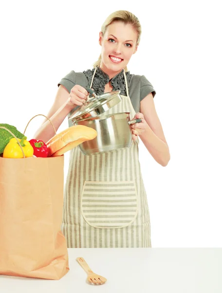 Mulher em uma cozinha e segurando uma panela — Fotografia de Stock