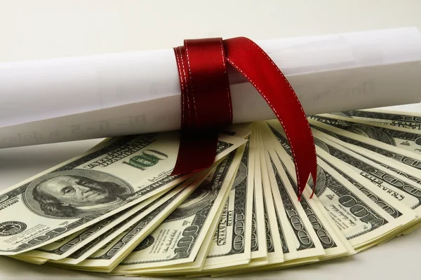 Close-up de dólares e um diploma — Fotografia de Stock