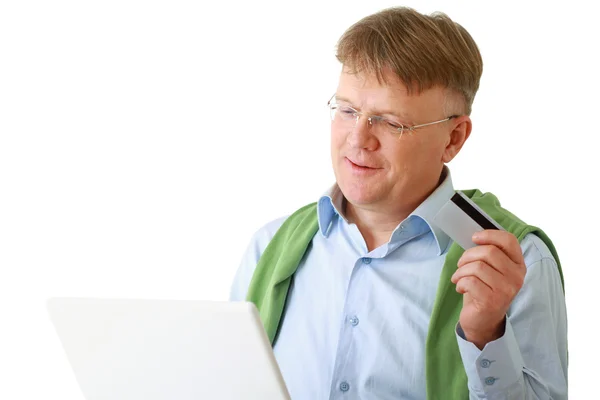 Un hombre con un portátil, con una tarjeta de crédito — Foto de Stock