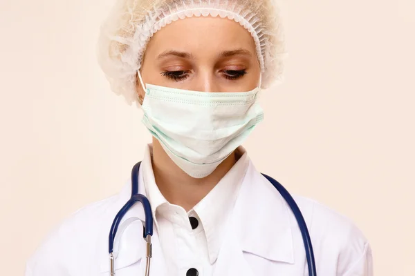 Young woman doctor with mask and cap — Stock Photo, Image