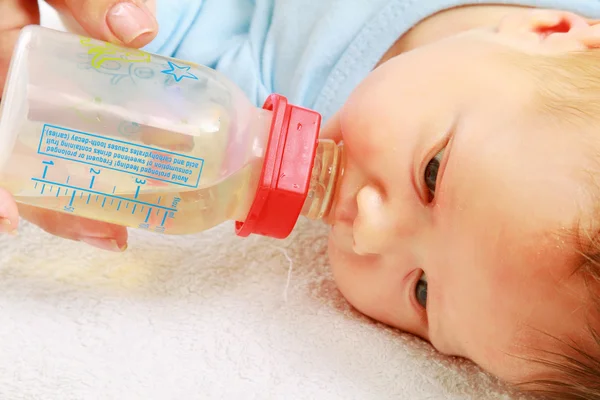 Feeding an infant with a feeding bottle — Stock Photo, Image