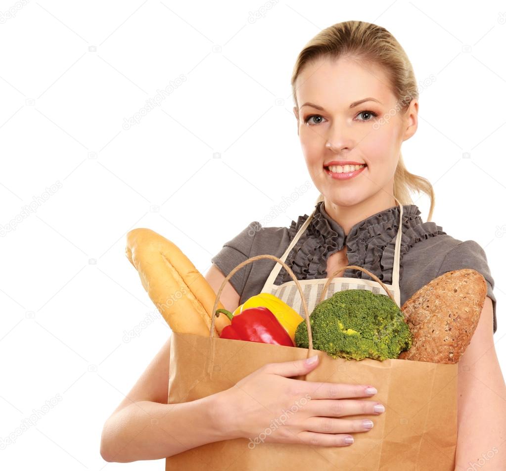 Woman in apron holding grocery bag