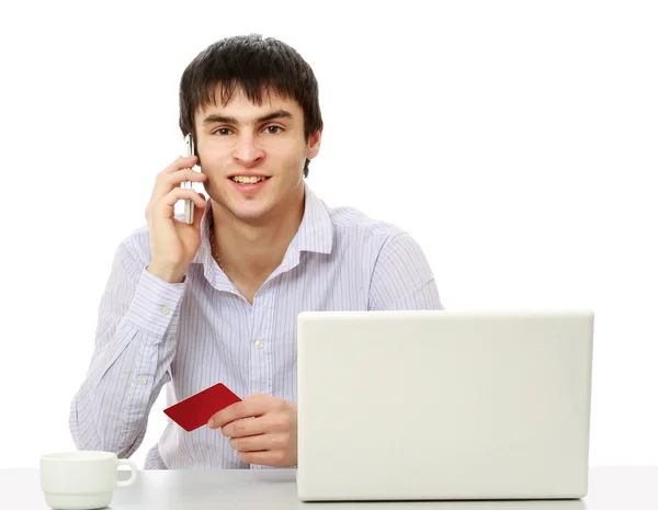 Hombre con tarjeta de crédito delante de un portátil —  Fotos de Stock