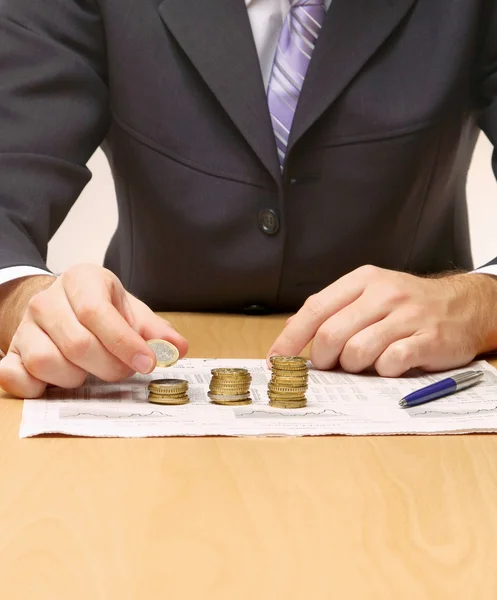Businessman putting the coins in columns — Stock Photo, Image