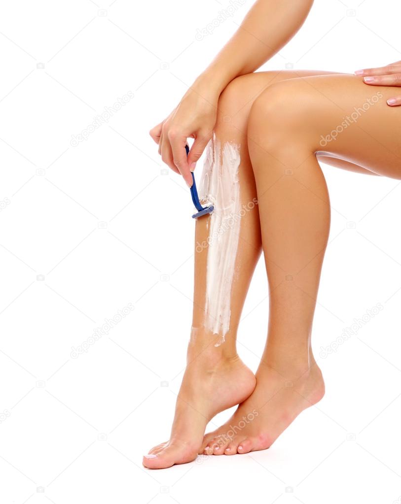 A woman is shaving her leg