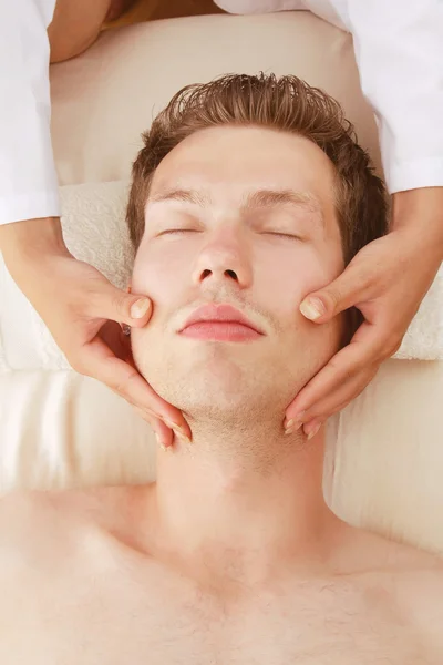 Uomo che riceve massaggio facciale da una donna — Foto Stock