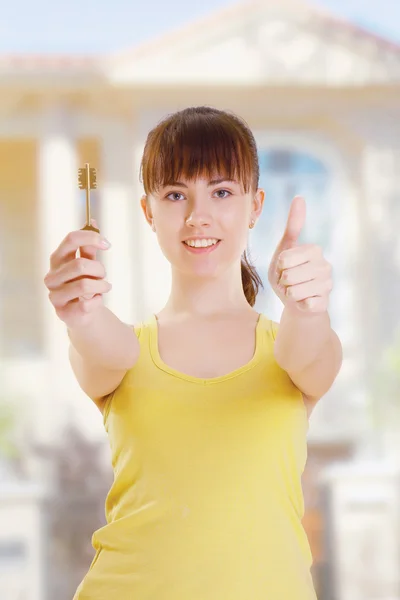 Woman with keys showing thumbs-up — Stock Photo, Image