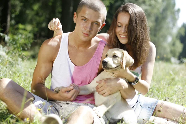 Genç bir çift ile bir köpek yavrusu — Stok fotoğraf