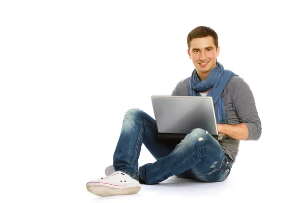 Bir dizüstü bilgisayar ile katta oturan adam — Stok fotoğraf