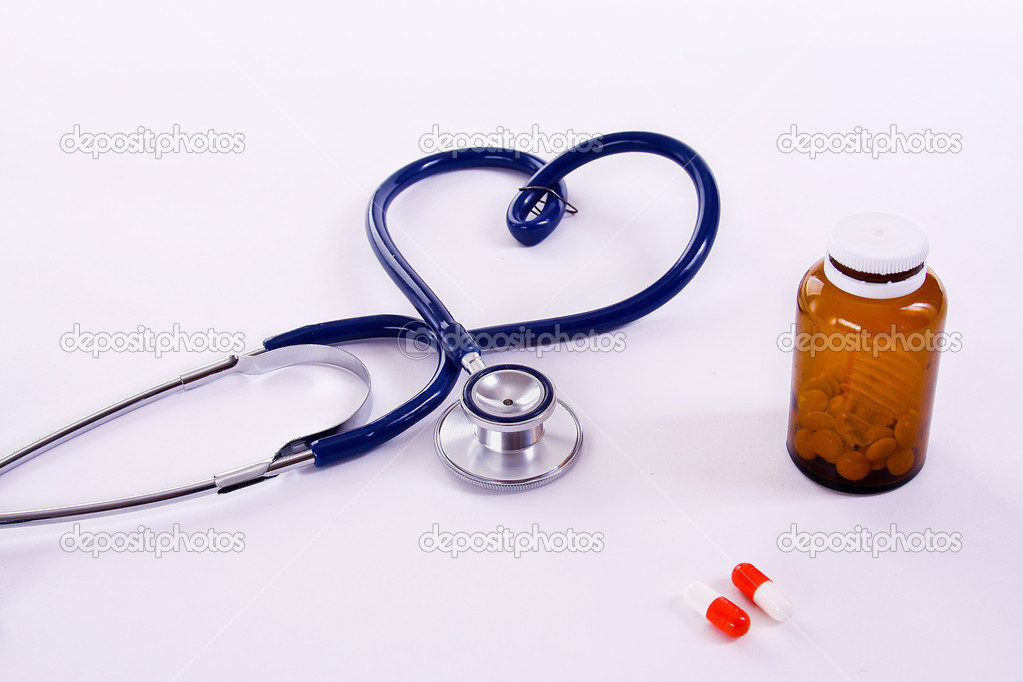 Stethoscope in a heart shape and pills