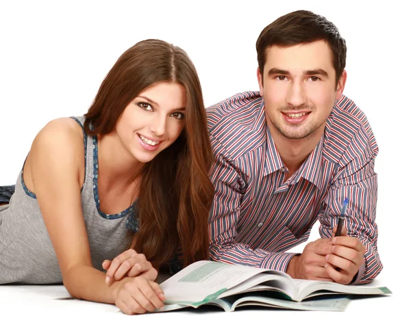 Jeune couple couché sur le sol avec des livres — Photo