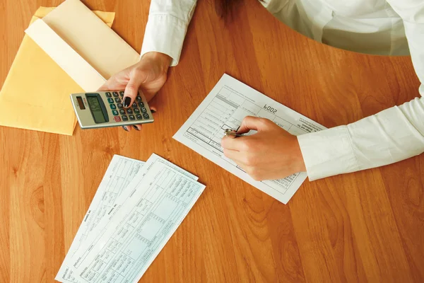 Jovem mulher usando uma calculadora . — Fotografia de Stock