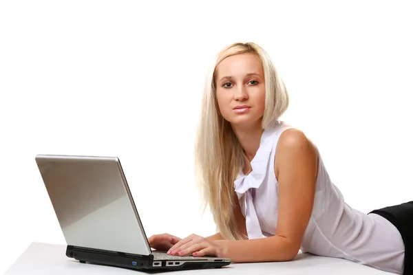 Una giovane bella donna sdraiata con un computer portatile — Foto Stock