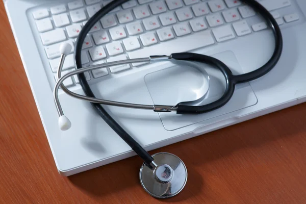 Stethoscope on silver laptop computer. — Stock Photo, Image