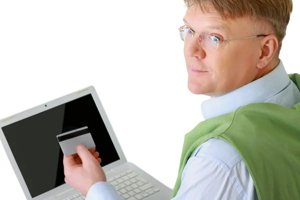 Homem com um laptop, segurando um cartão de crédito . — Fotografia de Stock