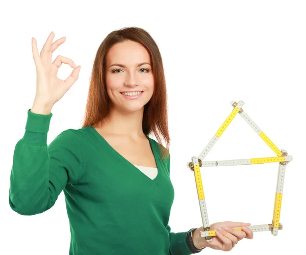 Woman holding a ruler in the form of a house and showing ok. — Stock Photo, Image