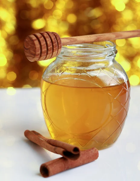 Honig mit Holzstäbchen und Zimtstangen. — Stockfoto