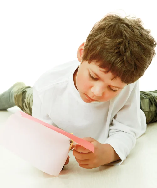 Junge schneidet Papier mit der Schere — Stockfoto