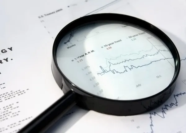 Lupa sobre jornal financeiro . — Fotografia de Stock